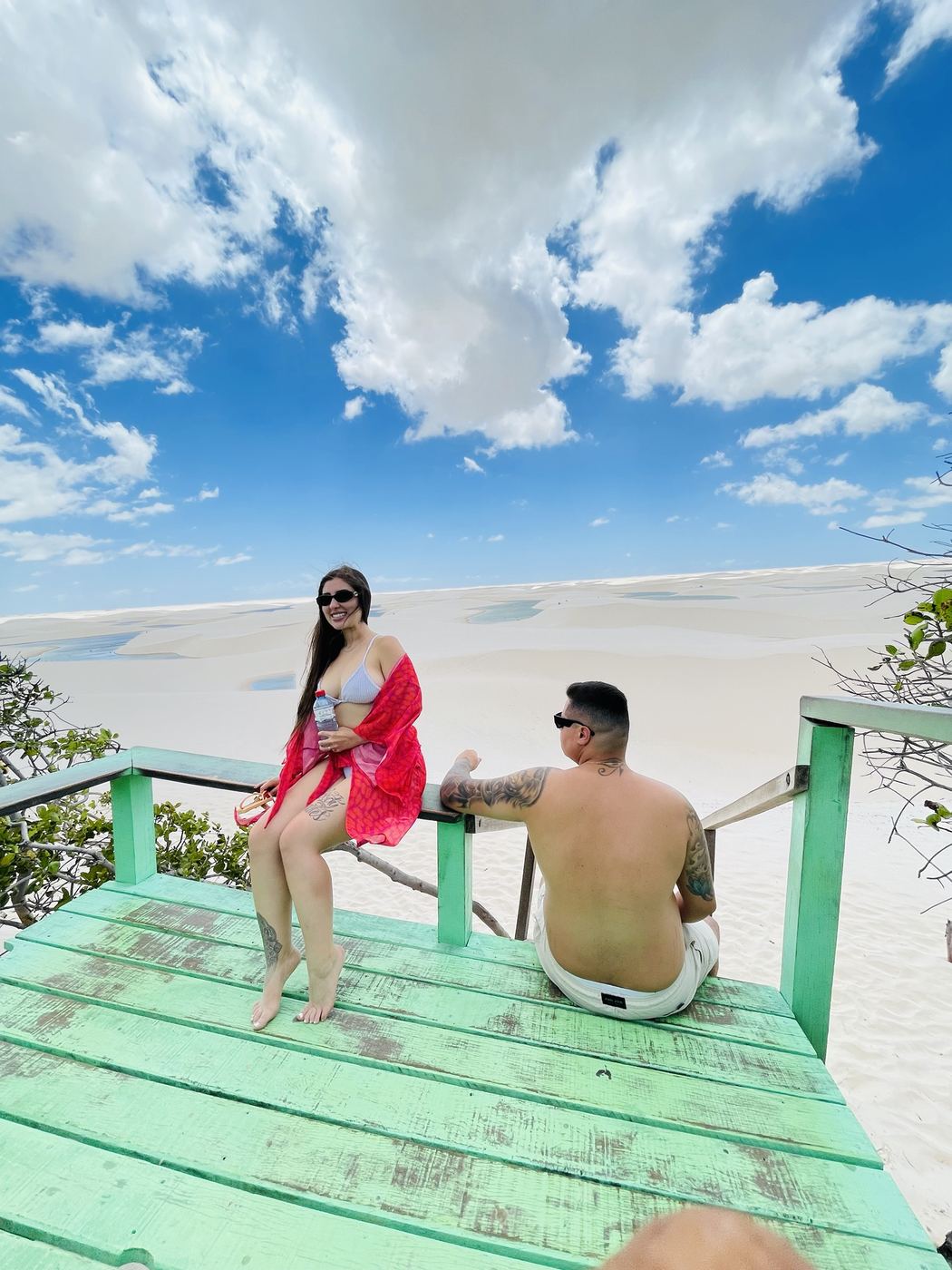 Casal no mirante de madeira com as dunas ao fundo